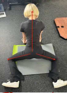 A picture showing the body body position and technique to isolate and stretch the superior fibers of the Adductor Magnus